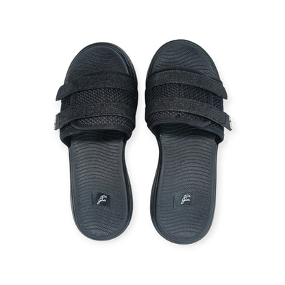 Pair of black slide sandals with textured footbeds and glittery double straps on white background