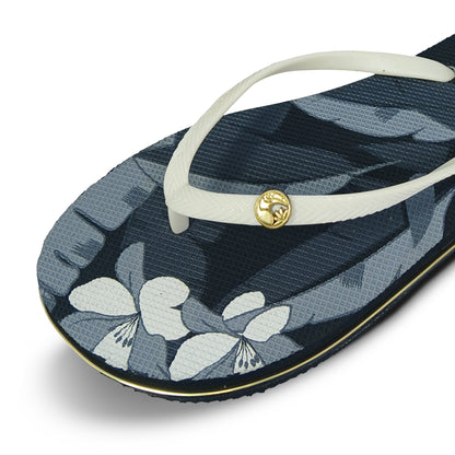 Toucantoes women's flip-flop with white straps, gold emblem, and floral print sole