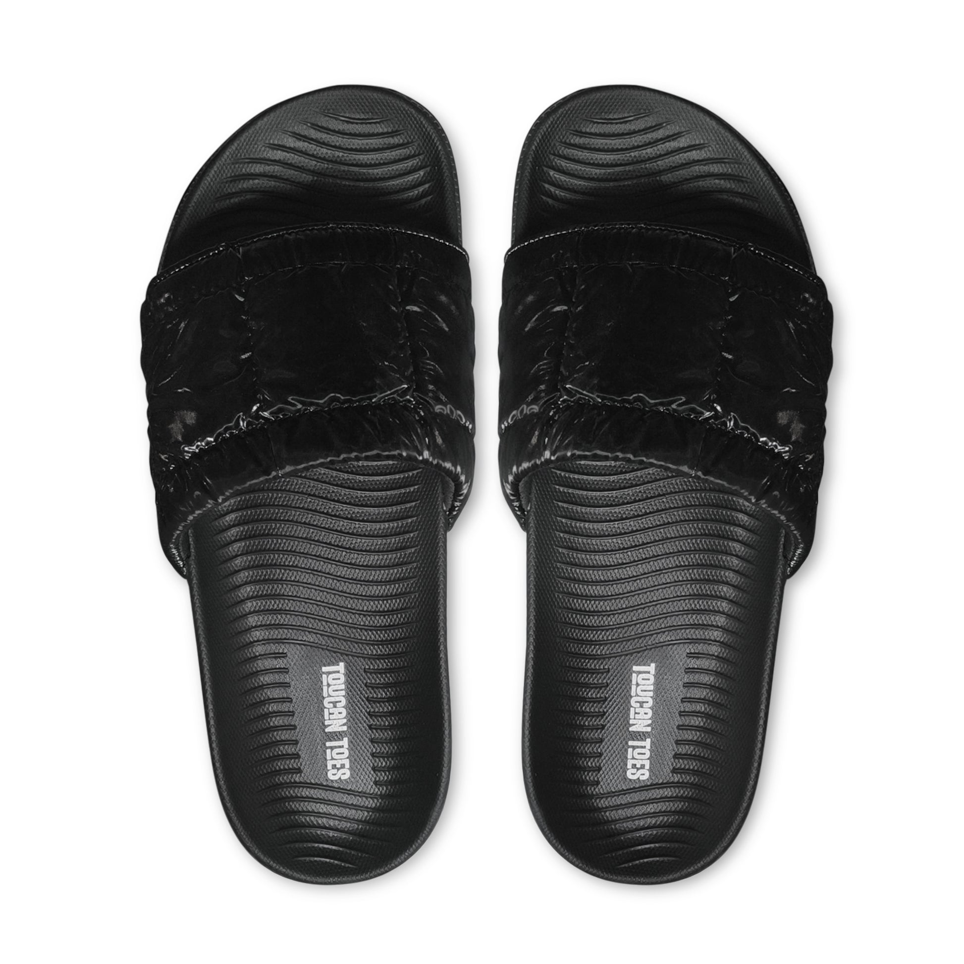 Top view of black cushioned slide sandals with textured footbed and Toucan Toes logo