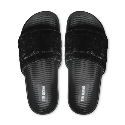 Top view of black cushioned slide sandals with textured footbed and Toucan Toes logo