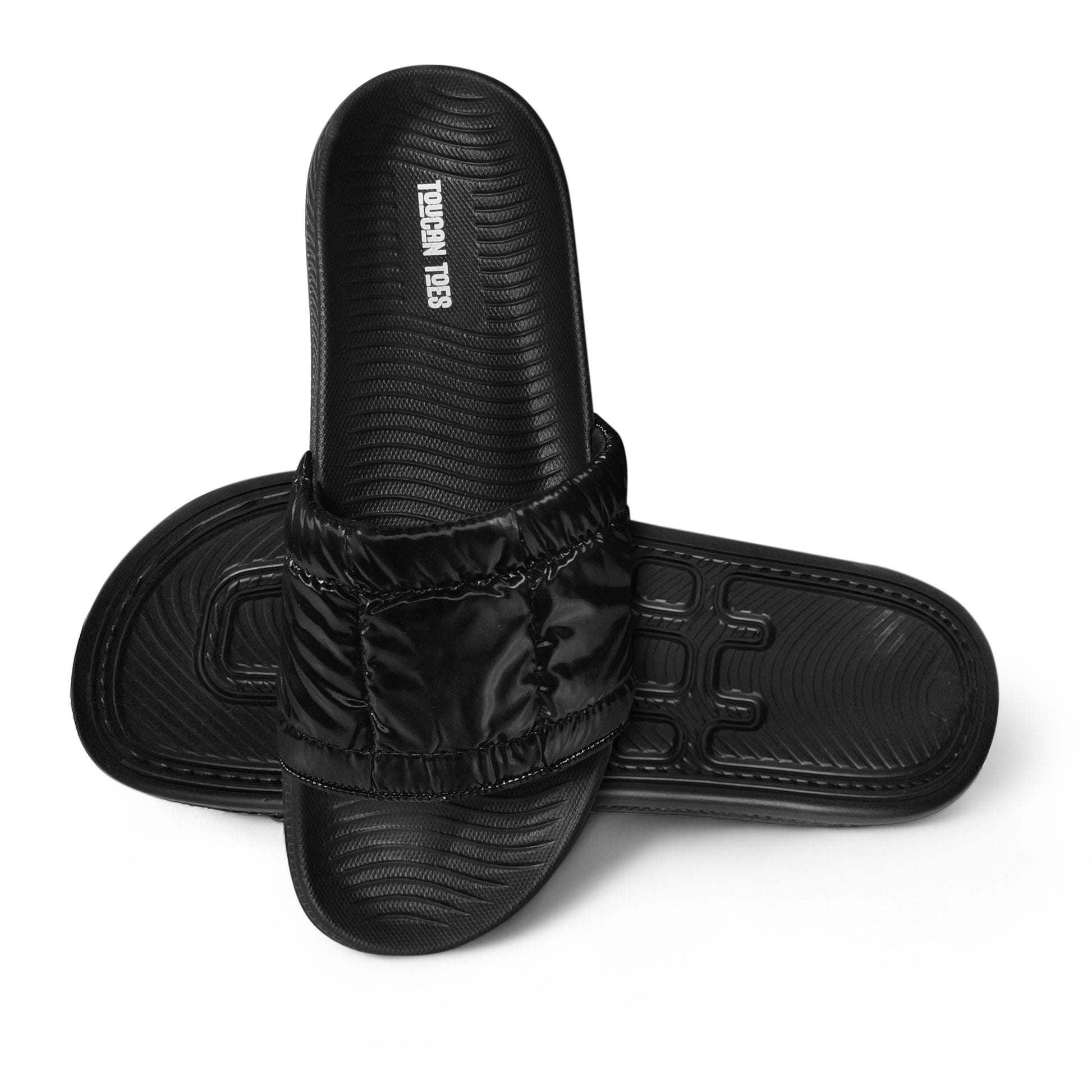 Black Toucan Toes slide sandals with cushioned strap and textured footbed isolated on white