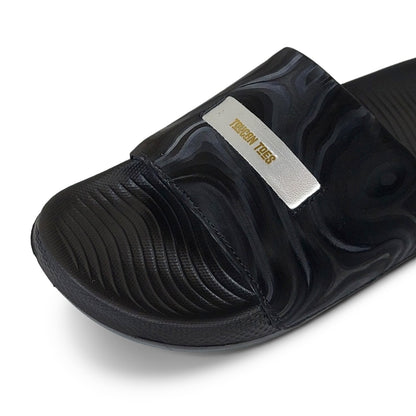 Black Toucantoes slide sandal with textured strap and gold logo, stylish comfortable footwear