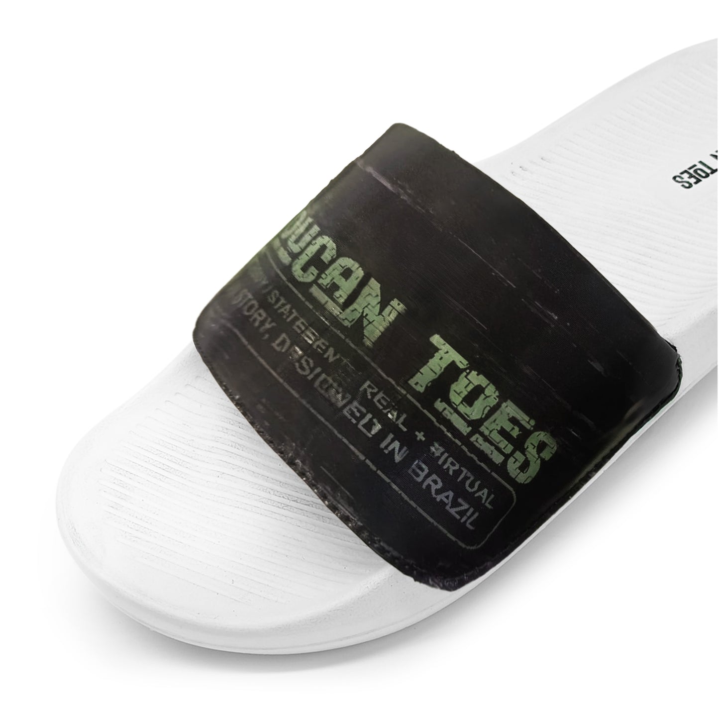 White slide sandal with black strap labeled Ocean Tides, designed in Brazil, close-up