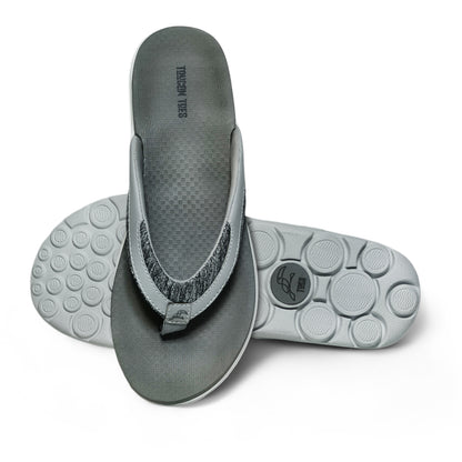 gray cushioned flip flops with textured footbed and circular tread sole on white background