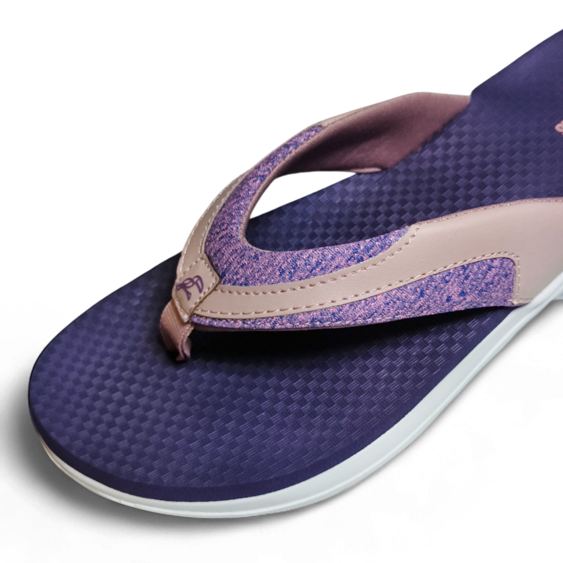 Close-up of navy blue and pink women's flip flop sandal with textured footbed and fabric strap