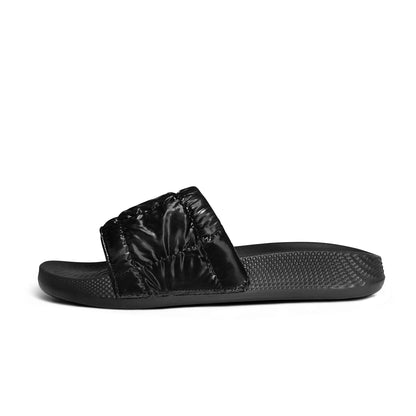 Black slide sandal with textured sole and padded shiny strap on white background
