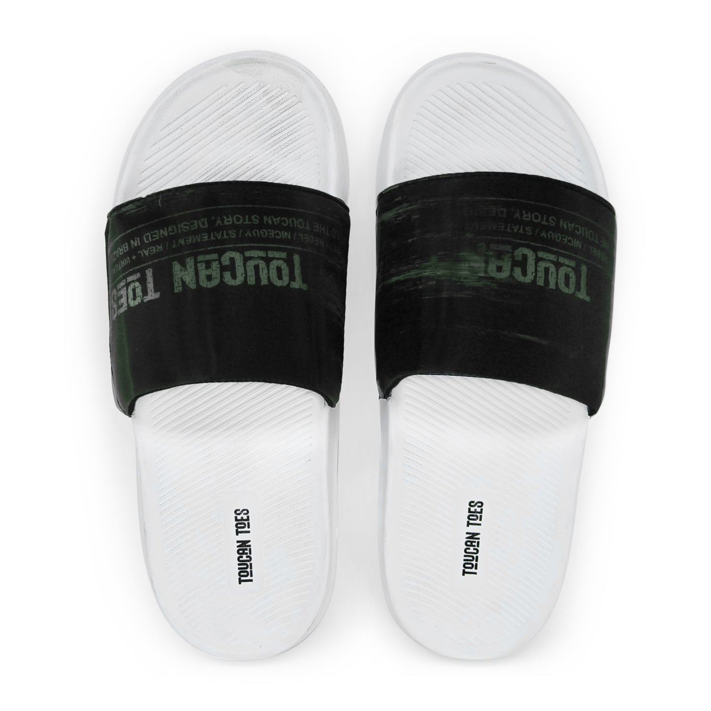 White slide sandals with black straps featuring faded Toucan Toes logo and textured footbed