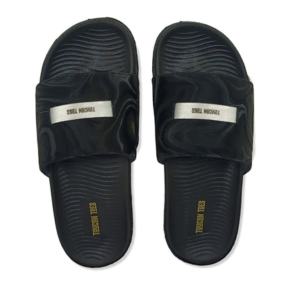 Toucan Toes black slide sandals with textured soles and logo straps, stylish durable footwear
