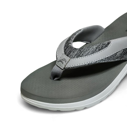 Close-up of gray cushioned flip flop with textured straps and white sole on white background