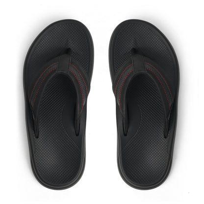 Pair of black textured flip-flop sandals with red stitching on white background