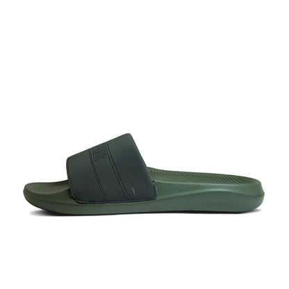 Side view of green and black slide sandal with textured sole and wide strap